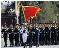关于如图所示国庆60周年大阅兵场景,下列说法错误的是A.迎风招展的红旗呈现红色,是因为红旗反射红色光B.士兵帽子上的军徽熠熠发光,因为军徽是光源C.整个
